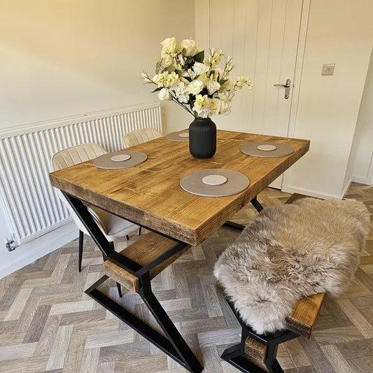 Dining area with a wooden table, chairs, and a vase of flowers.