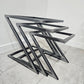 Three metal chair frames stacked on a tiled floor