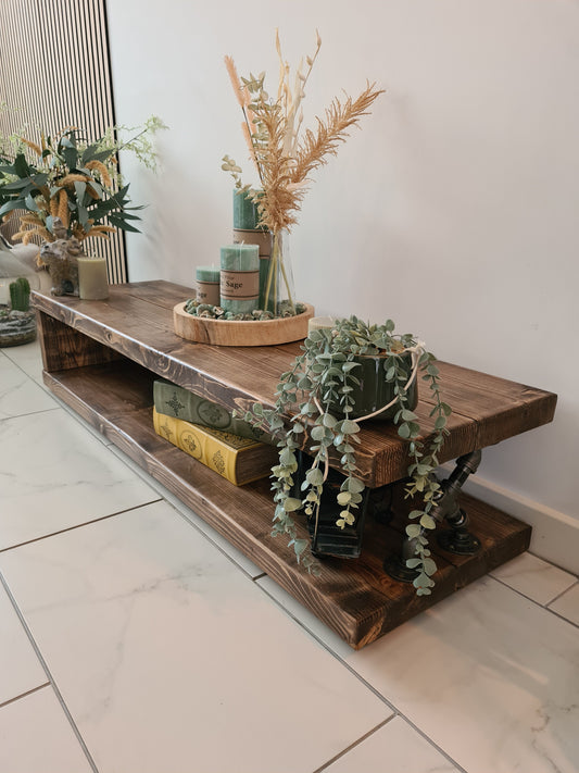 Wooden shelf with decorative items including plants and books on a tiled floor.
