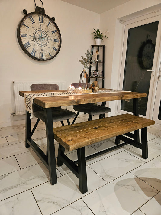 Wooden dining table with bench and decorative clock on wall in a room